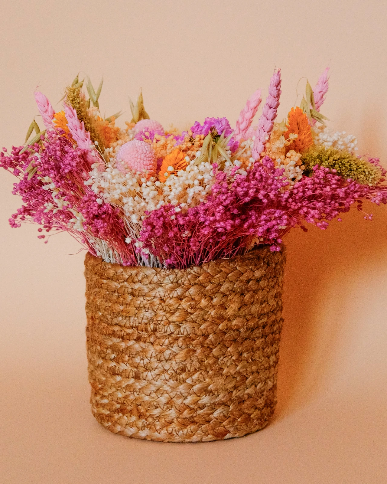 Cesto com flores secas e preservadas em tons rosa