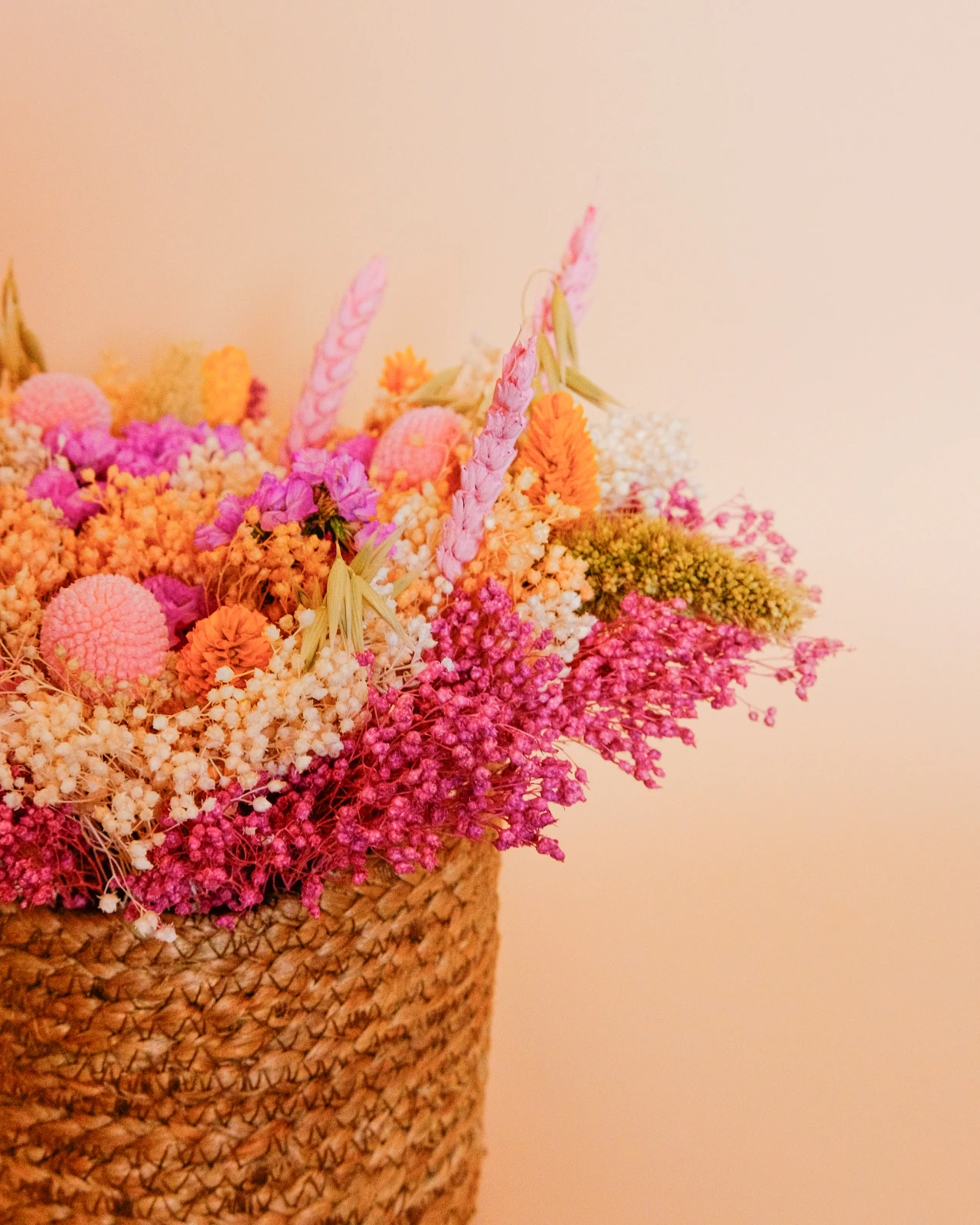 Cesto com flores secas e preservadas em tons rosa