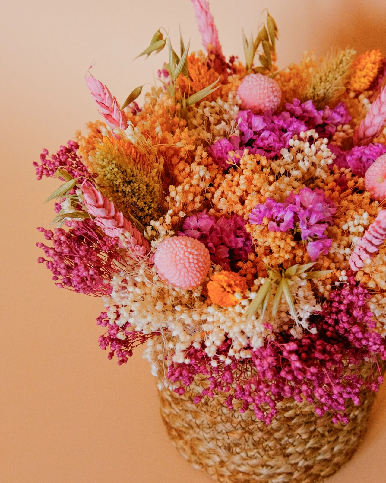 Cesto com flores secas e preservadas em tons rosa